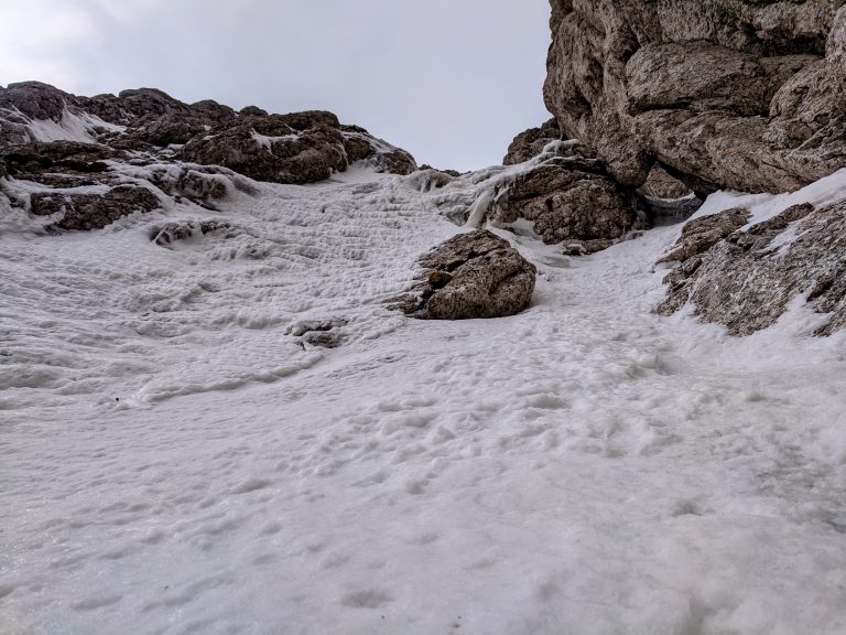 Vstop v strmi del smeri - sneg na levi je bil relativno slab, tako da sva se zbasala pod zagozdenim balvanom na levi. 
